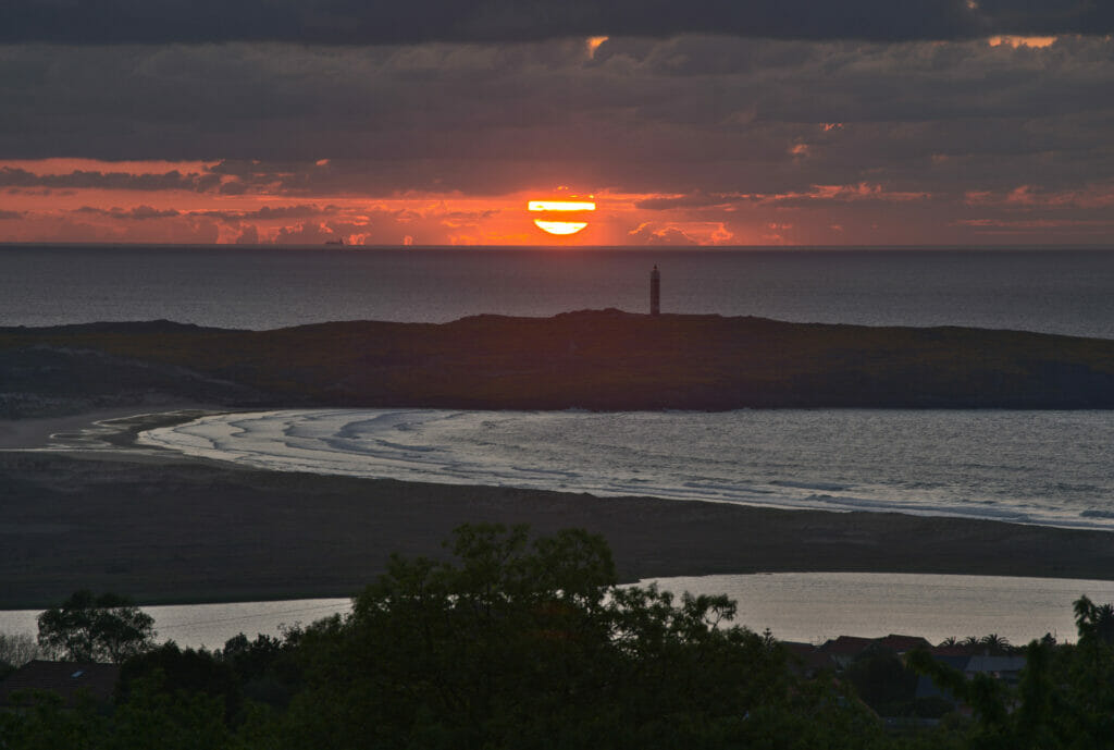 le soleil se couche derrière la phare de a Frouxeira