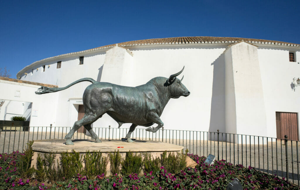statue of bull in front of the Ronda bullring