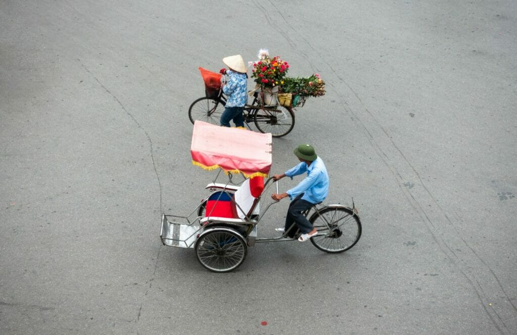 a rickshaw and a street vendor in the street