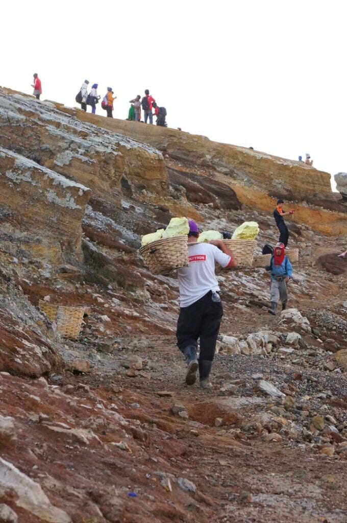 un porteur de soufre qui remonte du cratère du volcan en Indonésie