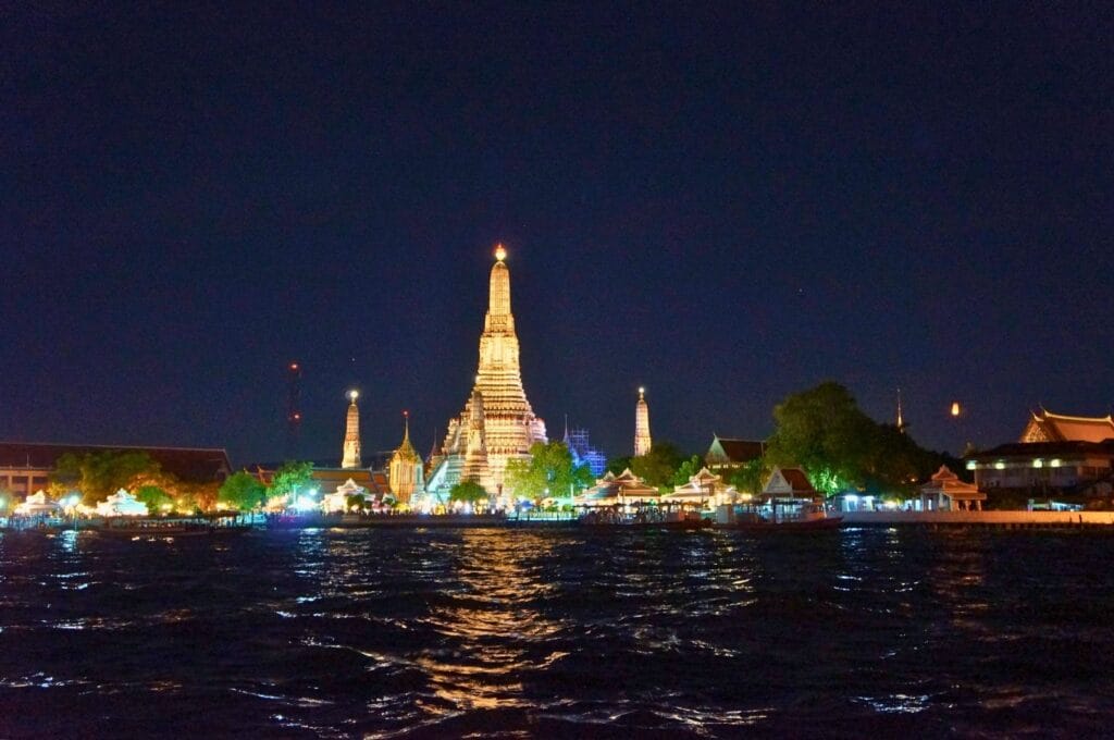 vue sur le temple Wat Arun illuminé de l'autre côté de la rivière Chao Phraya à Bangkok la nuit
