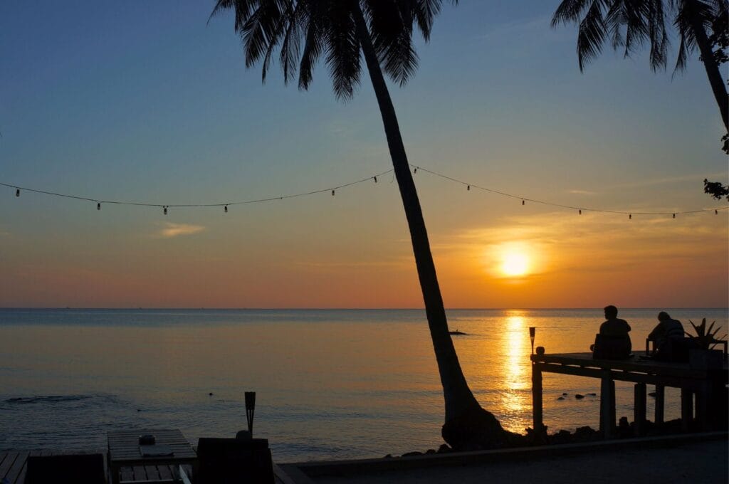 coucher de soleil sur le Golfe de Thaïlande derrière un palmier sur une plage de Koh Chang