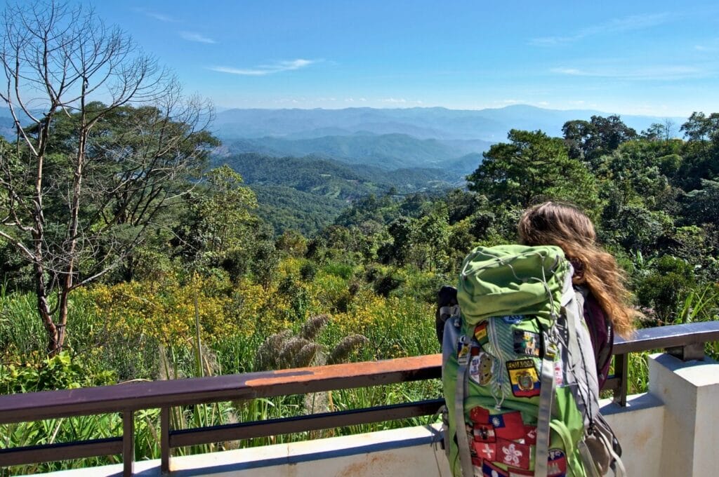 Fabienne and her backpack in front of the mountains during a stop on the loop