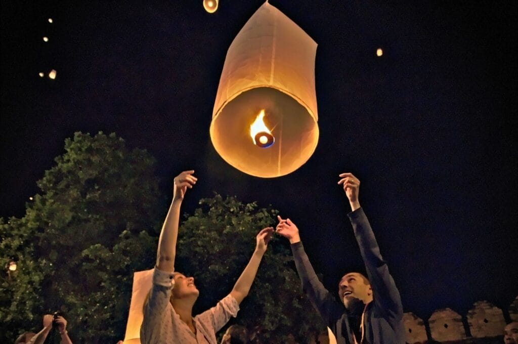Fabienne et Benoit lâchant leur lanterne dans le ciel en pleine nuit