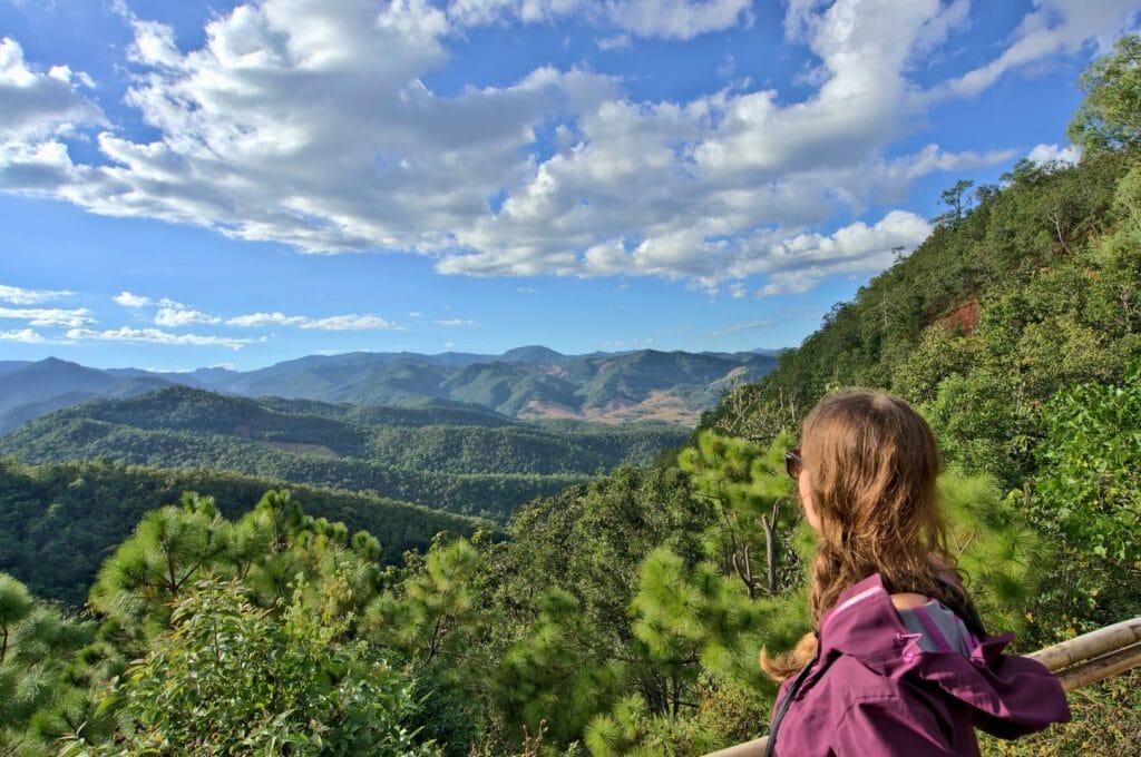 Fabienne devant un paysage vallonné et verdoyant dans la campagne thaïlandaise