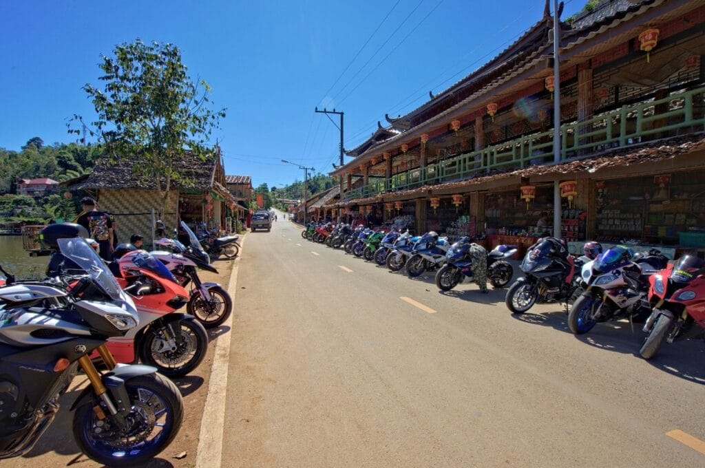 Motorcycles lined up on both sides of a Chiang Mai street