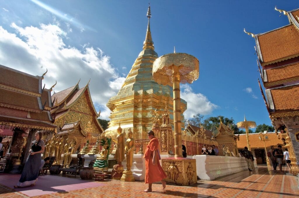 Moine devant un chedi doré sur le site du temple Wat Phra Doi Suthep