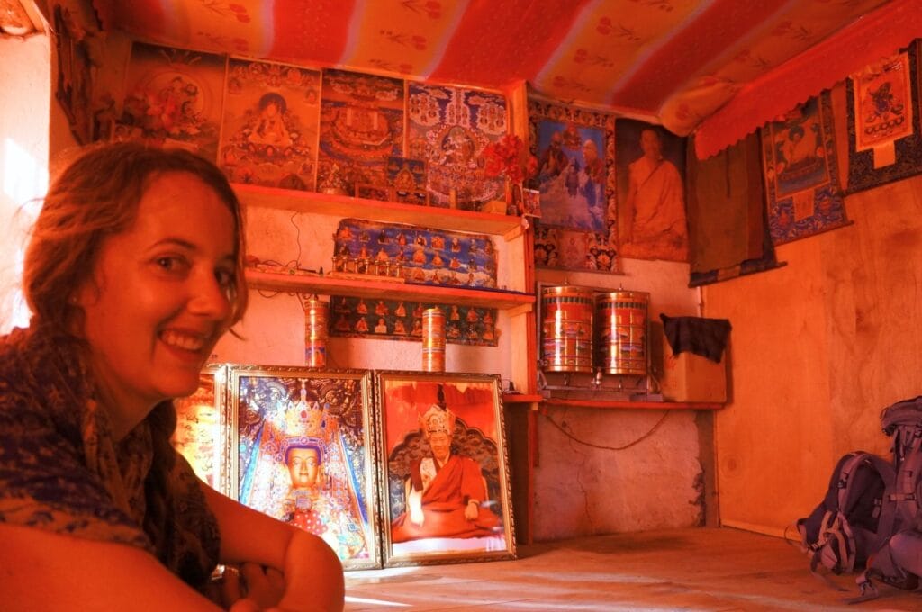 Fabienne dans une pièce avec plein d'objets dédiés aux lamas et au bouddhisme