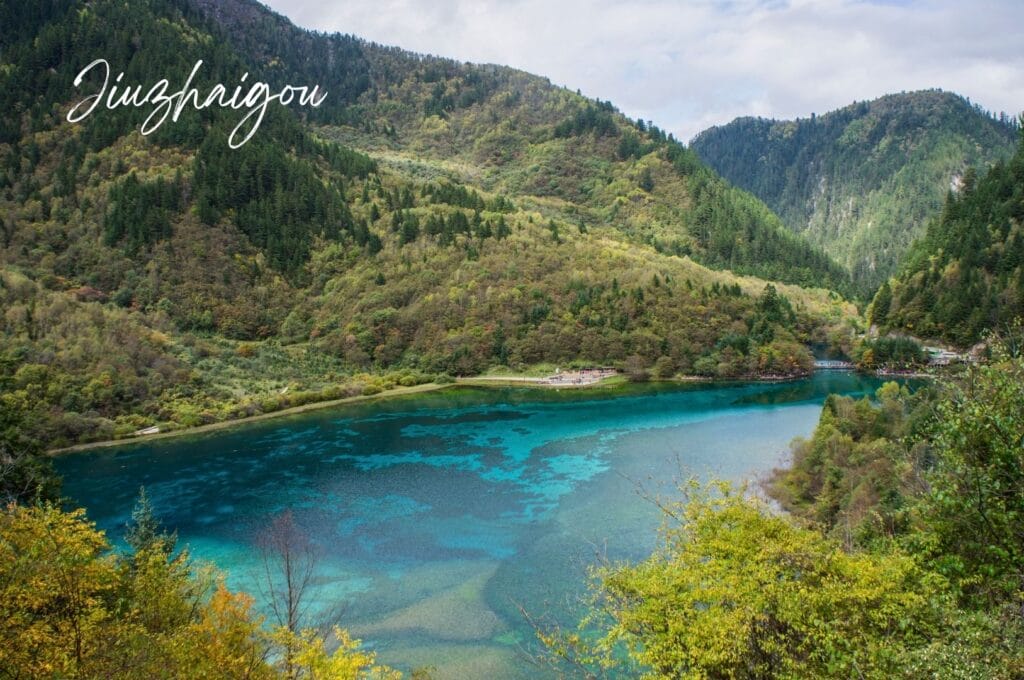 lac turquoise entouré de montagnes et de forêts dans la vallée de Jiuzhaigou