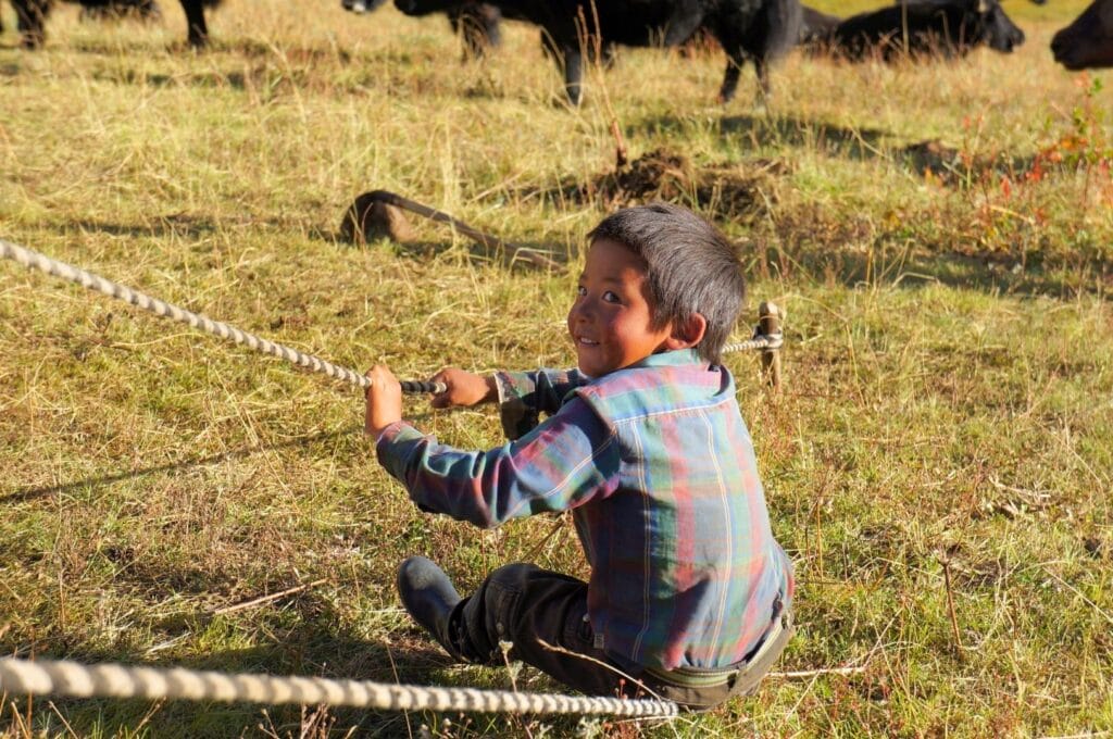 enfant nomade tibétain tirant sur une corde