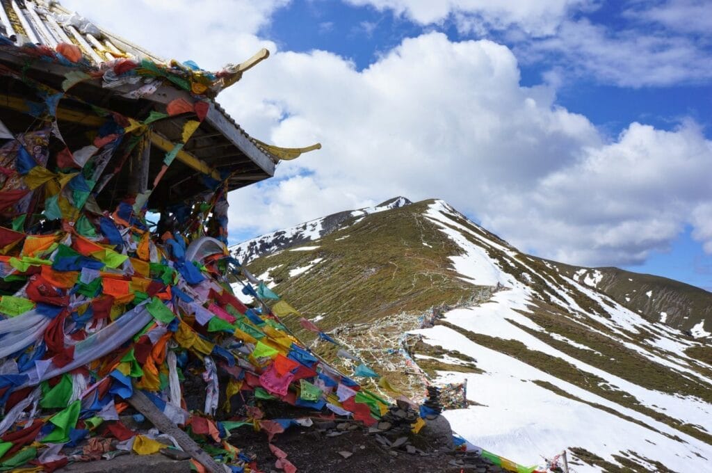 temple entouré de fanions colorés au sommet d'une montagne enneigée
