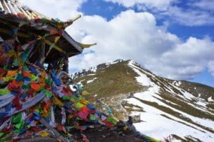 temple entouré de fanions colorés au sommet d'une montagne enneigée