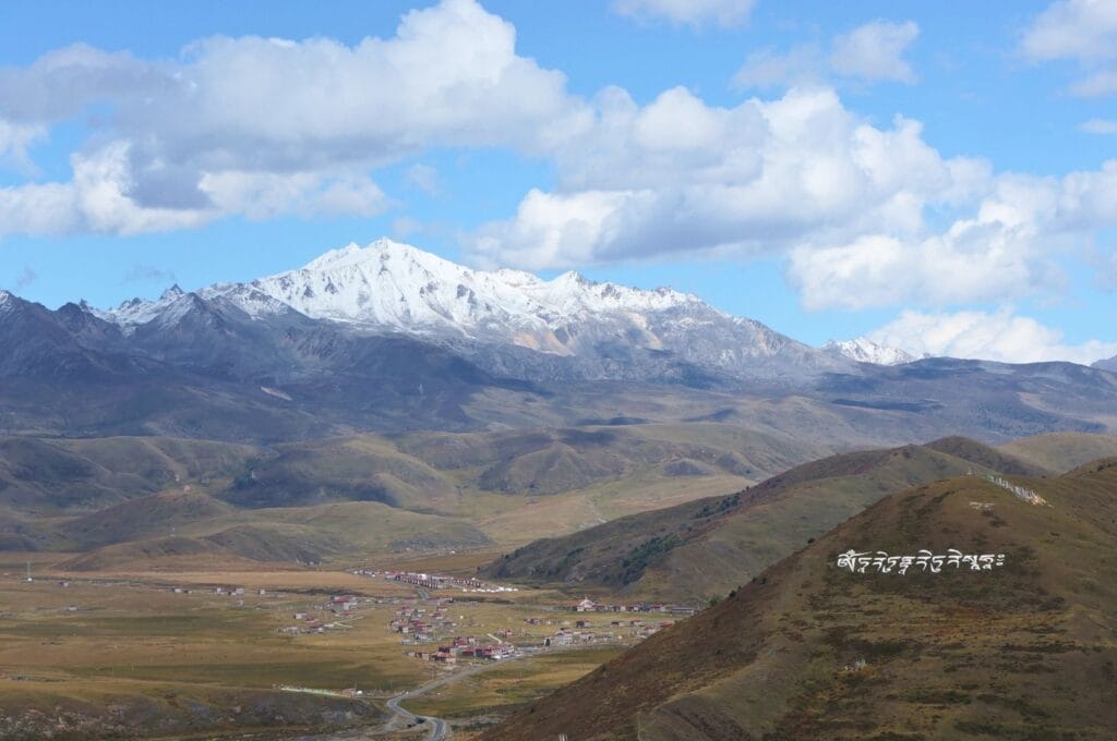 plaine tibétaine et massif montagneux enneigé au fond