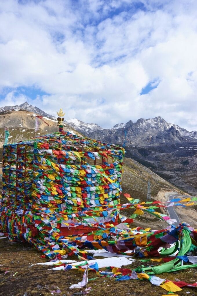 fanions colorés en haut d'une montagne avec les reliefs enneigés en arrière-fond