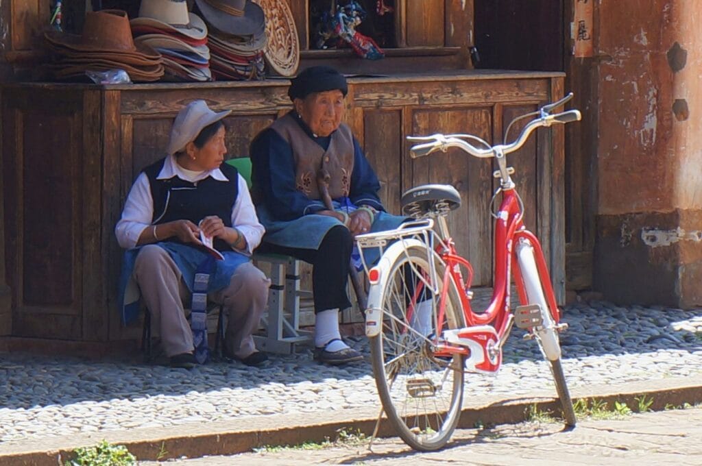 2 personnes âgées assises au bord de la route dans Shaxi
