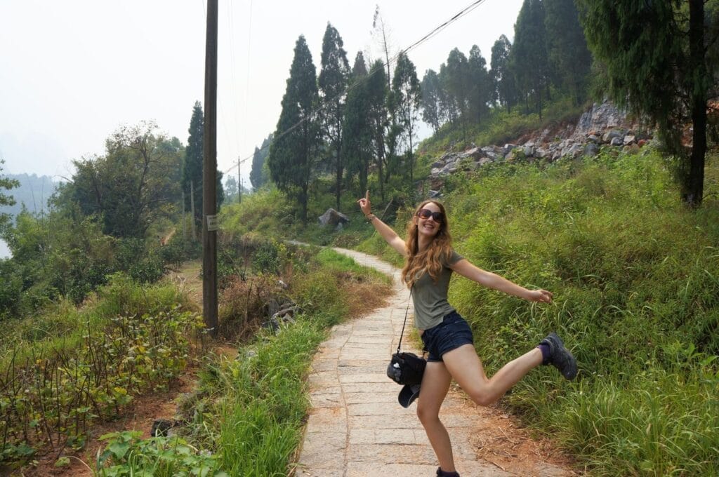 Fabienne sur un chemin pavé dans la campagne de Xingping