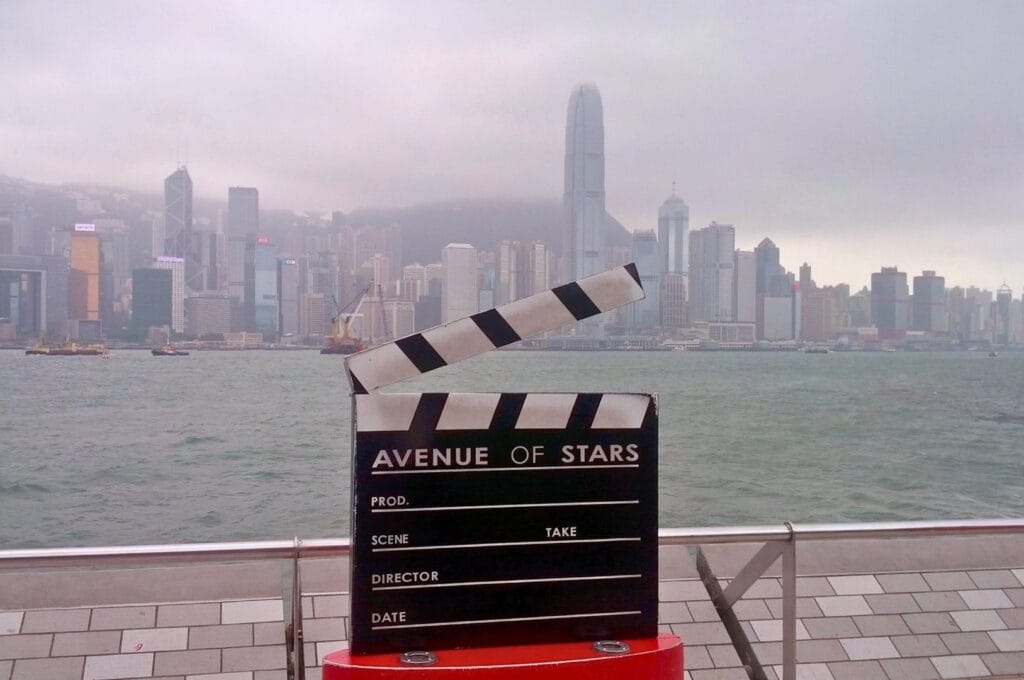 clap de cinéma indiquant l'avenue of stars avec la baie Victoria et la skyline en arrière-plan