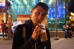 Benoit buvant un bubble tea dans une rue de Taipei