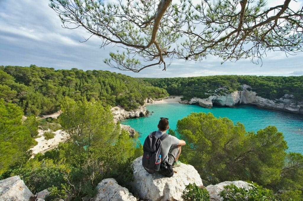 Benoit sur un rocher surplombant la crique Cala Mitjana