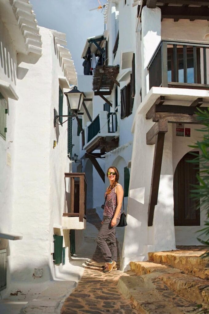 Fabienne dans une ruelle entre les maisons blanches du village de Binibequer