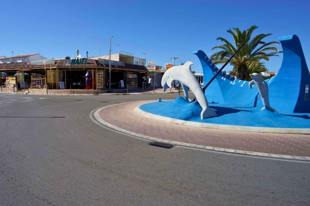 roundabout with blue dolphins in Cala Blanes, on the west coast of Menorca