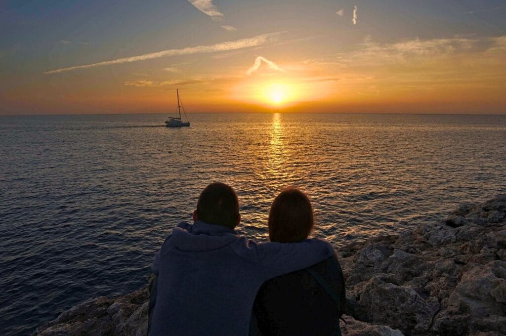 Fabienne et Benoit face au coucher du soleil à Cala Blanca à Minorque