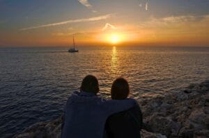 Fabienne et Benoit face au coucher du soleil à Cala Blanca à Minorque