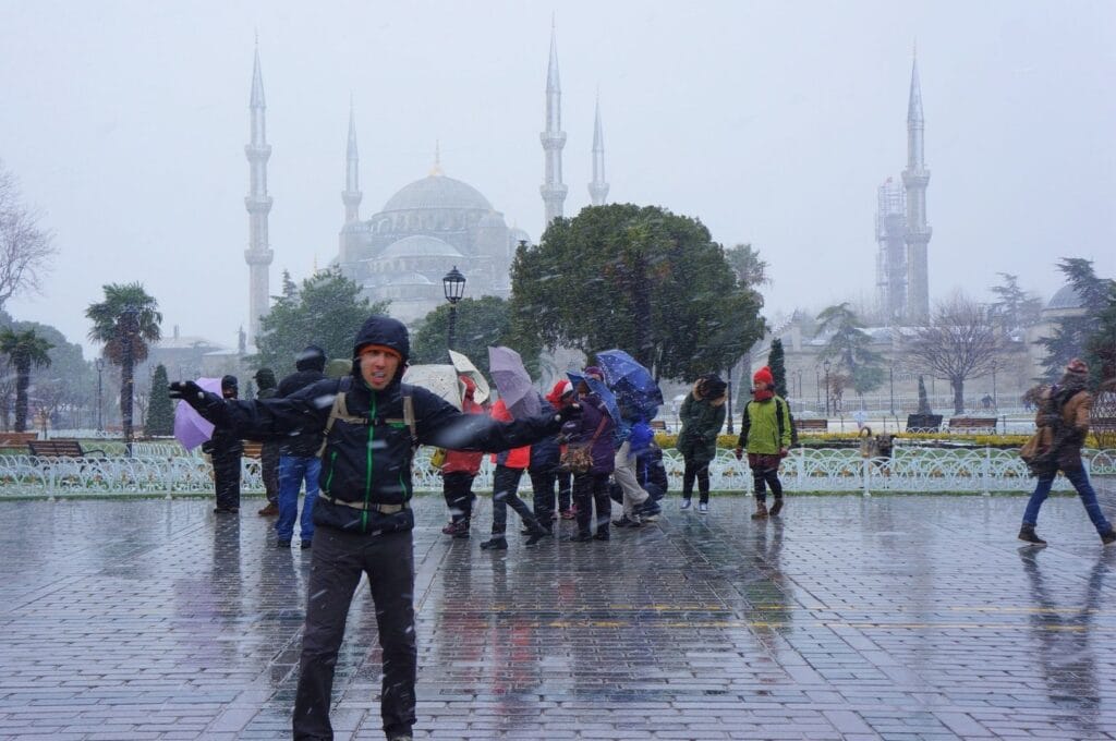 Benoit et des touristes sous la neige devant la mosquée bleue